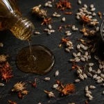aceite de cártamo prensado en frío de brotes germinados en botella de vidrio sobre superficie oscura